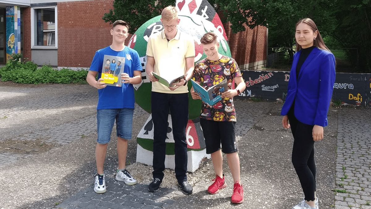 Drei ukrainische Schüler und eine Schülerin auf dem Pausenhof