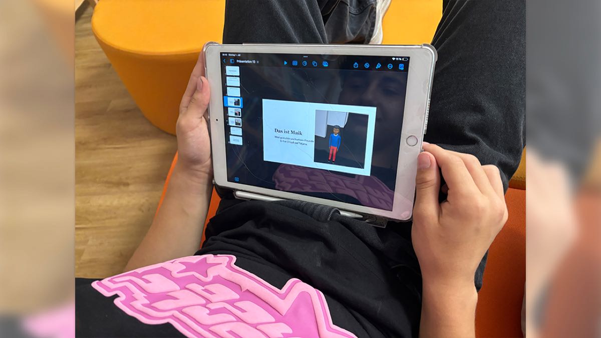 Bild: Man sieht ein Kind, das auf ein Tablet schaut.